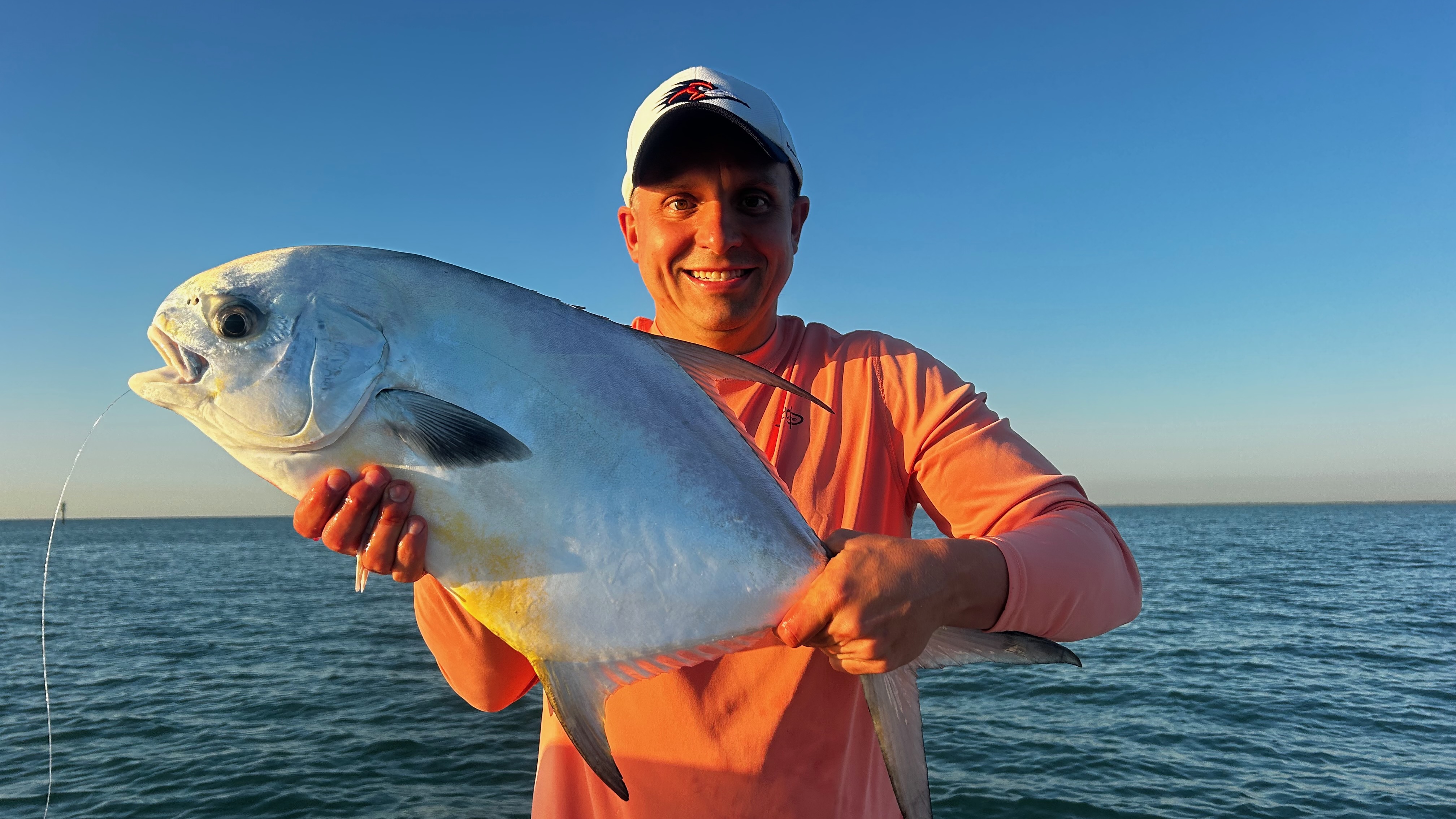 Happy angler holding a large permit caught on a Miami Bay Fishing Charter on Biscayne Bay Florida